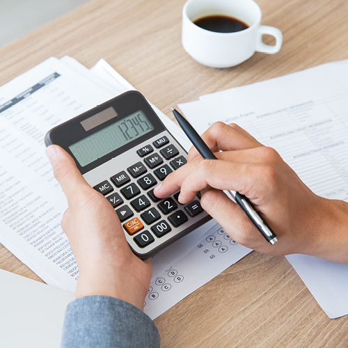 Person using calculator at a desk with papers